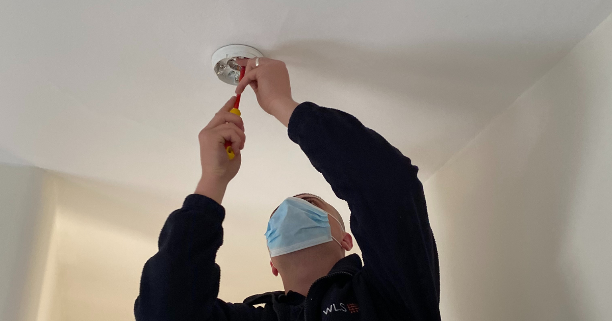 WLS engineer fixing a fire alarm